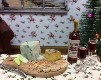 Miniature Stilton cheese and Farmhouse cheddar cheeseboard with assorted crackers and sticks of celery. With hand blown glass wine glasses.