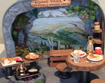 Dino Park, Camping and Picnic Suitcase Diorama. A jurassic camping experience with camp fire, table, seating, food & storage trunk.