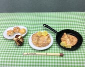 Easter Shrove Tuesday accessories. Easter Egg, Hot Cross Buns on a platter, pancake with lemon and sugar and pancake in a frying pan.