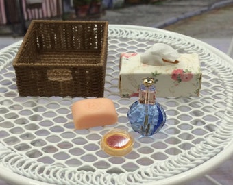 Miniature bathroom set for dollhouse. A little basket with box of tissues, lip gloss, soap and perfume bottle.  Fascinatingly realistic