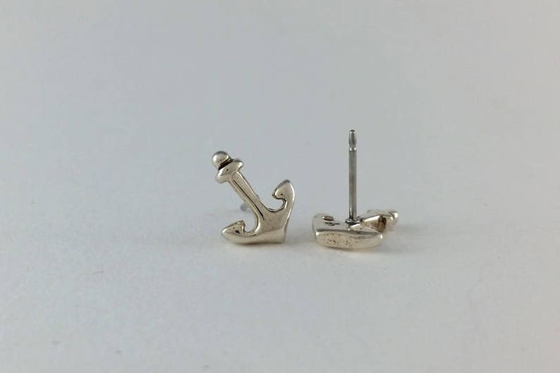 K&ouml;nnte beinhalten: Ein Paar silberne Anker-Ohrstecker. Die Ohrringe sind klein und zart und w&auml;ren ein tolles Geschenk f&uuml;r jemanden, der das Meer liebt.