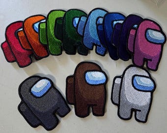 May include: A collection of twelve embroidered patches shaped like characters in various solid colors including red, orange, lime green, dark green, light blue, royal blue, navy, purple, pink, dark gray, brown, and light gray, each with a light blue visor.