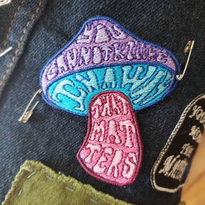 Könnte beinhalten: Ein gestickter Aufnäher in Form eines Pilzes mit dem Text "You Shroom, I'll Take The Fat Tears". Der Pilz ist rosa, blau und lila.