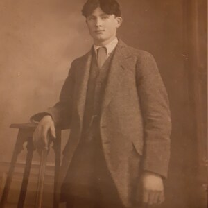 Photo vintage carte postale jeune homme à la sellette