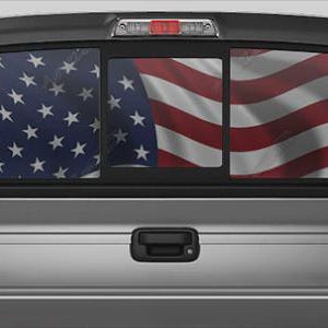 Può includere: Un pick-up argentato con un lunotto posteriore con un design a bandiera americana. La bandiera è divisa sui pannelli del finestrino, con il campo blu di stelle a sinistra e le strisce rosse e bianche a destra.