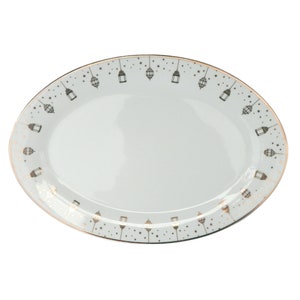 May include: White oval serving platter with a gold rim and a pattern of black lanterns and gold stars.
