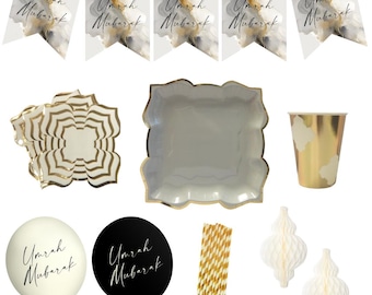 May include: A party supply set featuring Umrah Mubarak pennant banners with abstract gray and gold ink patterns, scalloped white and gold plates, gold metallic cups, white and black balloons with text, gold striped paper straws, and white honeycomb ornaments.