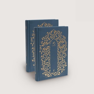 May include: Two navy blue hardcover books with gold geometric designs. The books have the text "99 Names" in gold. The covers feature a central vertical design with a floral pattern surrounding it. The books are stacked slightly.