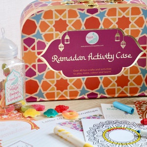 May include: A colorful Ramadan Activity Case with a geometric pattern, a jar of Halal sweets, and craft supplies. The case features the text "Ramadan Activity Case" and "Over 40 fun crafts and activities".