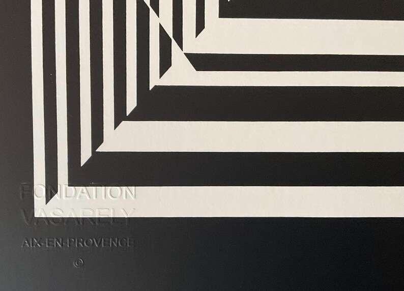 May include: Black and white abstract geometric art print with a white background and black lines. The print features a repeating pattern of squares and rectangles that create a sense of depth and perspective. The print is signed "Fondation Vasarely Aix-en-Provence".