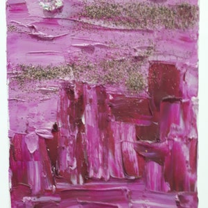 Op de afbeelding: Abstract schilderij met roze en rode penseelstreken en glitteraccenten.