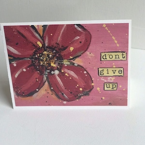 May include: A pink and red flower with yellow accents is painted on a pink background with yellow splatters. The words "dont give up" are written in black letters on a yellow background.