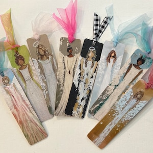May include: Eight painted wooden bookmarks featuring angels with different colored wings and halos. The bookmarks are tied with colorful ribbons.