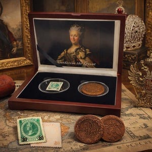 May include: A wooden display case with a portrait of Catherine the Great and the text "Catherine the Great." The case contains a stamp and a coin. Additional stamps and coins are displayed on a map.