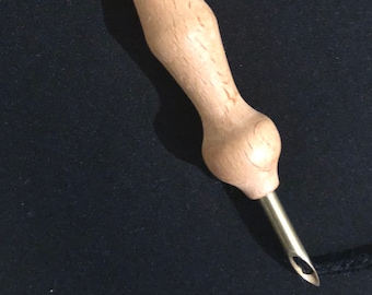 May include: A wooden crochet hook with a smooth, rounded handle and a metal needle with a small eye. The hook is designed for use with yarn or thread.