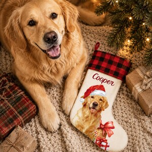 May include: A cream-coloured Christmas stocking featuring a red and black buffalo plaid cuff, the name Cooper in red script, and a graphic of a golden retriever wearing a Santa hat with red gift boxes at the bottom of the stocking.
