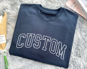 May include: A dark blue sweatshirt with the word "CUSTOM" in white outlined letters.