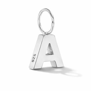 May include: A silver letter "A" charm with a loop for attaching to a necklace or bracelet. The charm is made of polished metal and has the number "925" stamped on the side. The letter casts a shadow.