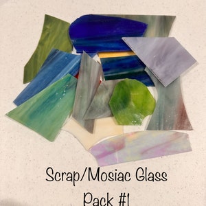 May include: A variety pack of scrap glass pieces in various colors and shapes, including blue, green, purple, and white. The glass pieces are perfect for mosaic projects. Scrap/Mosaic Glass Pack #1