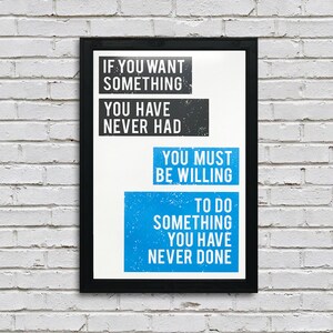 May include: A motivational quote poster with a black frame and white background. The quote reads: "If you want something you have never had, you must be willing to do something you have never done."