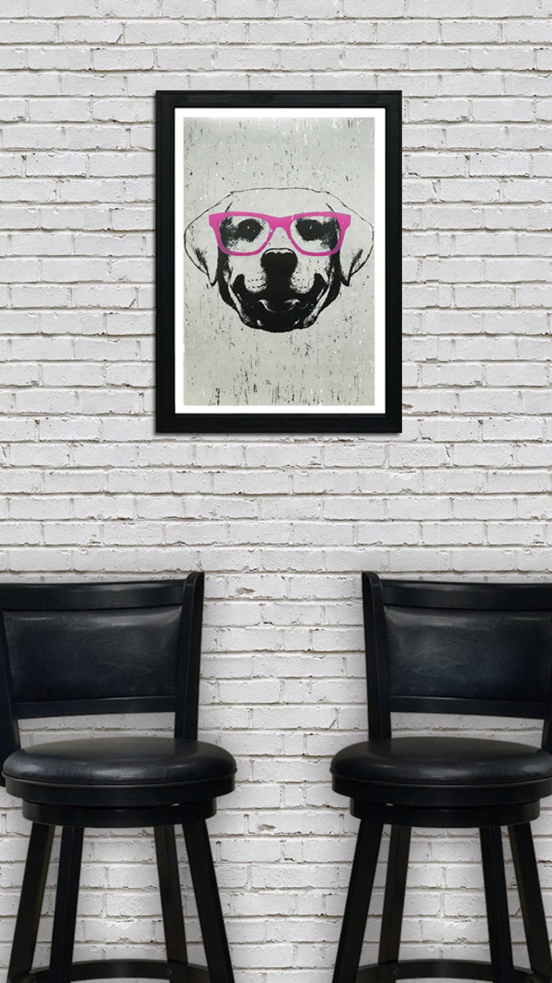 May include: A black and white illustration of a dog wearing pink glasses. The illustration is framed and hanging on a white brick wall. Two black bar stools are in front of the wall.