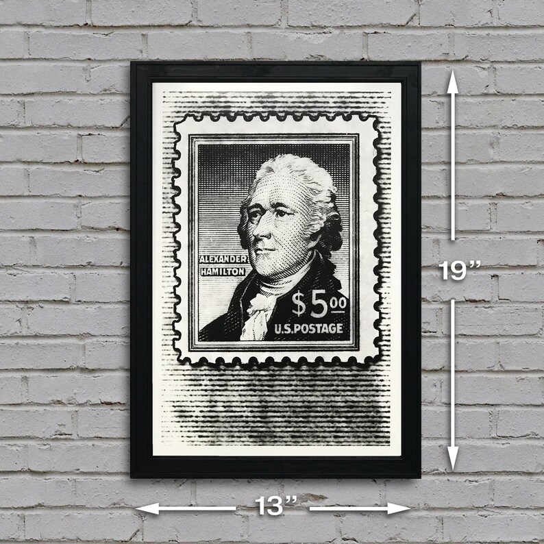 May include: Black and white print of a vintage postage stamp featuring a portrait of Alexander Hamilton with the text "Alexander Hamilton $5.00 U.S. Postage". The print is framed in a black frame and measures 13 inches wide by 19 inches tall.