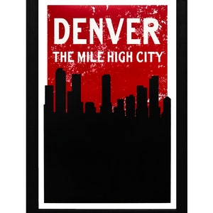 May include: Framed art print featuring the word "DENVER" in white capital letters above the text "THE MILE HIGH CITY" on a distressed red background. A black silhouette of a city skyline is at the bottom.