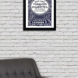 May include: A vintage advertisement for Harris & Sons high class tobaccos and cigarettes, featuring an ornate design with a navy blue background and white text. The text reads "High Class Tobaccos and Cigarettes Obtainable Everywhere Factories London E."