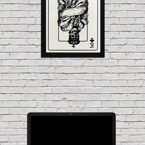 May include: Black and white illustration of the King of Clubs playing card. The King is a skeleton wearing a crown and is bound by a ribbon. The card is framed in black.