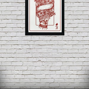 May include: A framed illustration of the King of Diamonds playing card. The card features a red skull wearing a crown and a ruff collar. The card is set against a white brick wall with a pile of poker chips in the foreground.