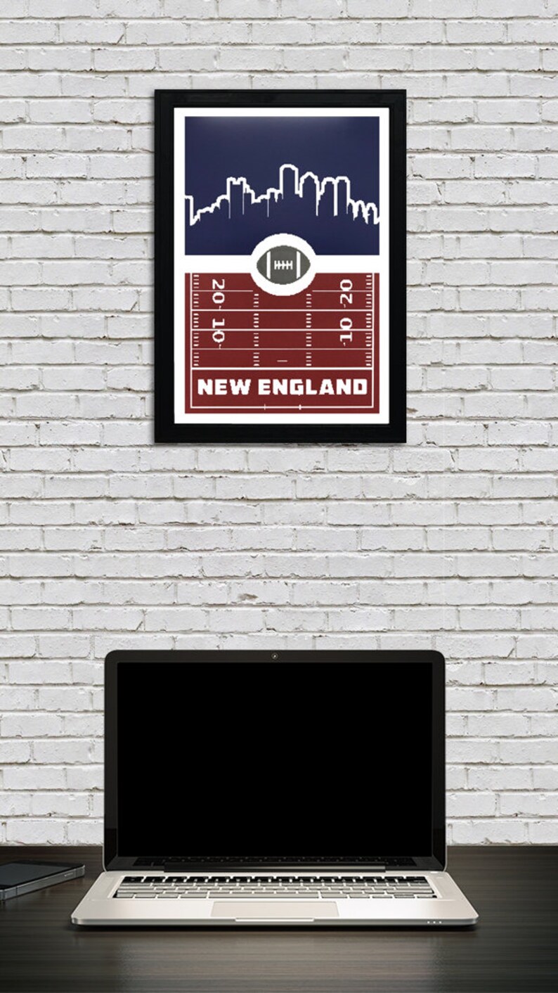 May include: A framed print with a navy blue background featuring a white silhouette of a city skyline. The bottom of the print has a red and white football field design with the text "NEW ENGLAND" and yard lines marked "20", "10", and "10-20".