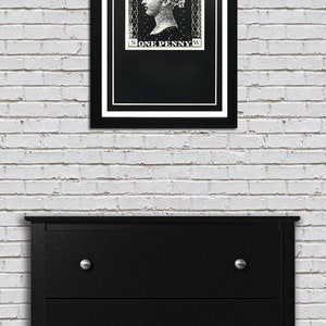 May include: A black and white framed print of a vintage postage stamp featuring a woman's profile and the text "POSTAGE ONE PENNY".