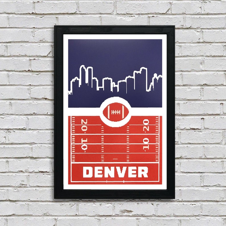 May include: A red, white, and blue Denver Broncos themed print with a skyline of the city and a football field with the word "DENVER" in the center.