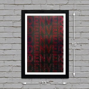 May include: A black framed poster with the word "DENVER" repeated five times in a red, gradient font on a dark background. The poster is 13 inches wide and 19 inches tall.