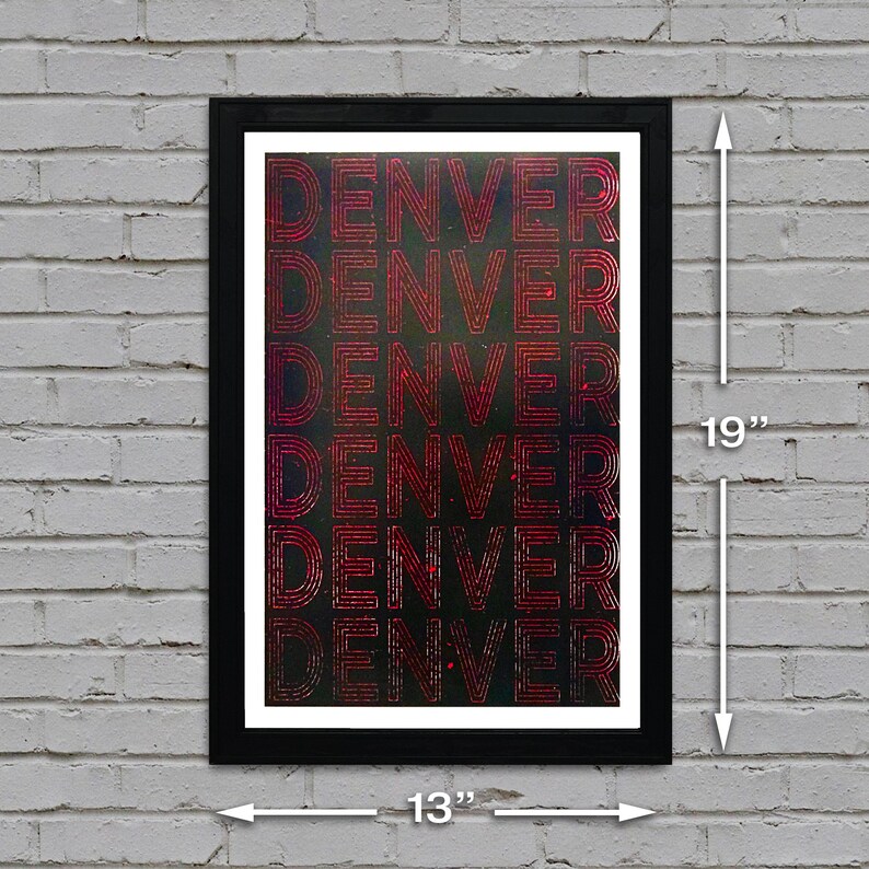 May include: A black framed poster with the word "DENVER" repeated five times in a red, gradient font on a dark background. The poster is 13 inches wide and 19 inches tall.