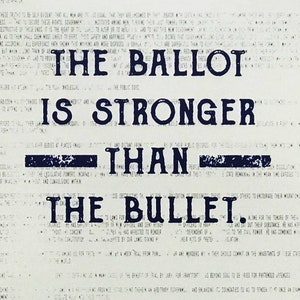 May include: A black and white image with the text "The Ballot is Stronger Than The Bullet." The text is in a bold, blocky font and appears to be printed on a newspaper.