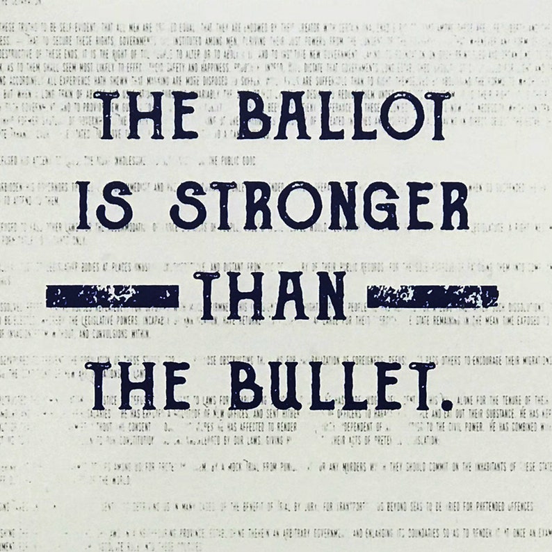 May include: A black and white image with the text "The Ballot is Stronger Than The Bullet." The text is in a bold, blocky font and appears to be printed on a newspaper.