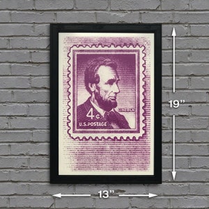 May include: A framed print of a vintage 4-cent US postage stamp featuring a portrait of Abraham Lincoln. The stamp is in shades of purple and white, with the text "LINCOLN" and "U.S. POSTAGE" printed on it. The frame is black and measures 13 inches wide by 19 inches tall.