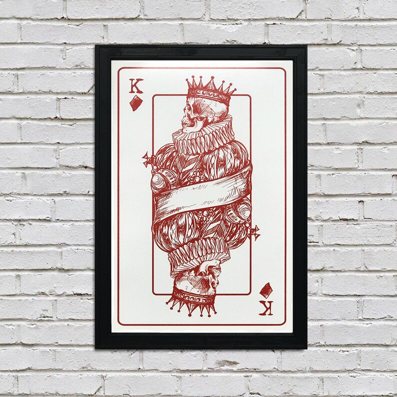 May include: A framed print of a playing card featuring a king of spades. The king is depicted as a skeleton wearing a crown and a robe. The card is in a black frame.
