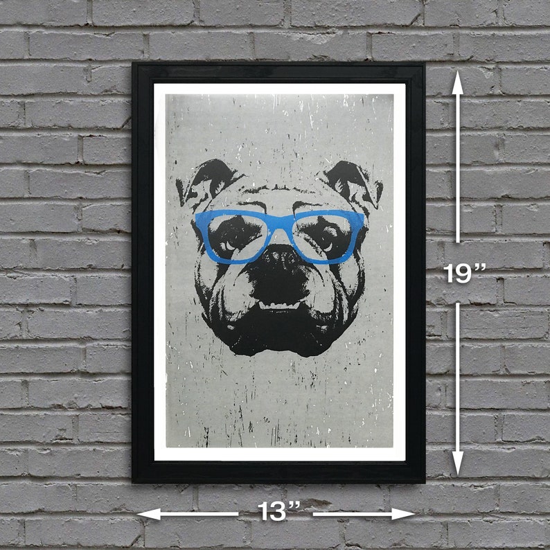 May include: A black and white illustration of a bulldog wearing blue glasses. The image is printed on a textured, gray background. The print is framed in a black frame and measures 13 inches wide by 19 inches tall.
