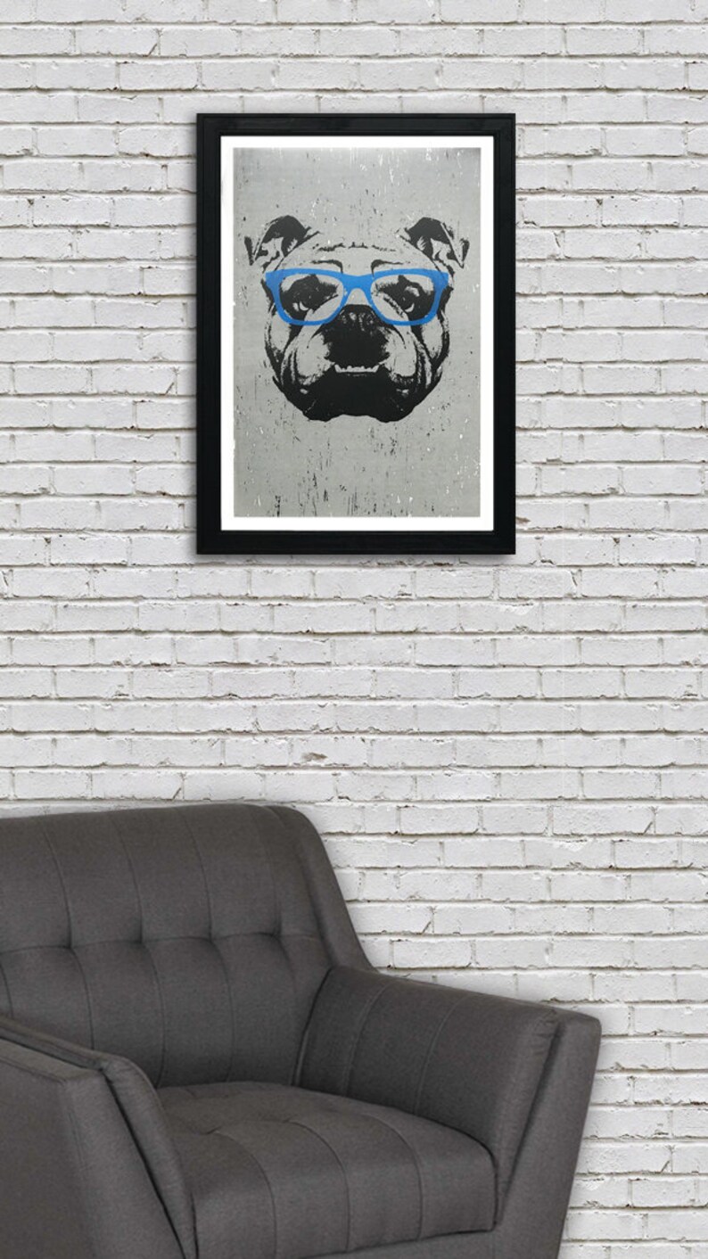 May include: A black and white illustration of a bulldog wearing blue glasses. The illustration is printed on a white background and framed in a black frame.