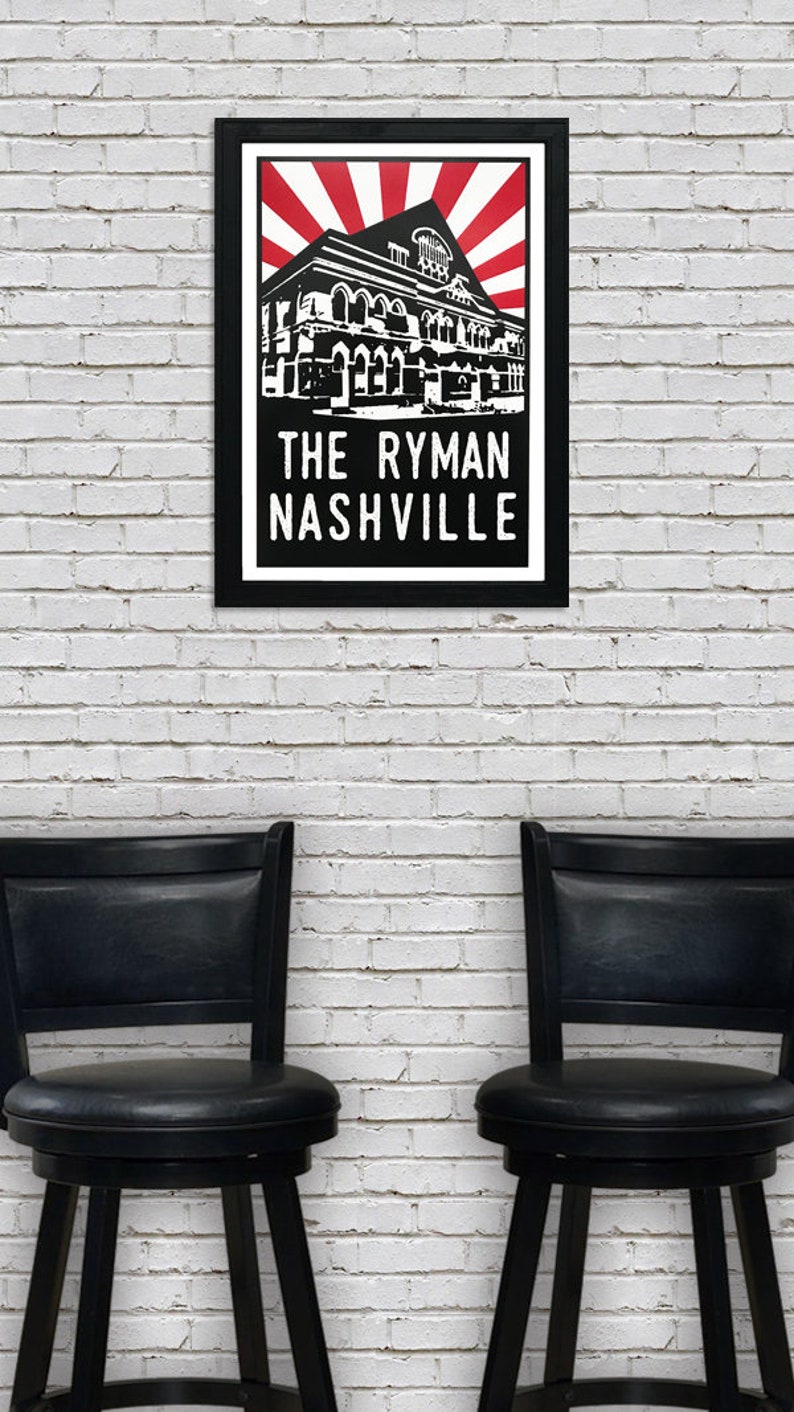 May include: Black and white illustration of the Ryman Auditorium in Nashville, Tennessee. The building is depicted with a red and white sunburst behind it. The text "The Ryman Nashville" is printed below the building.