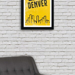 Puede incluir: Un p&oacute;ster enmarcado en negro con fondo amarillo y un gr&aacute;fico de baloncesto negro. El texto "DENVER" est&aacute; escrito en letras negras en el p&oacute;ster. Una silueta negra de un horizonte de ciudad se encuentra en la parte inferior del p&oacute;ster.