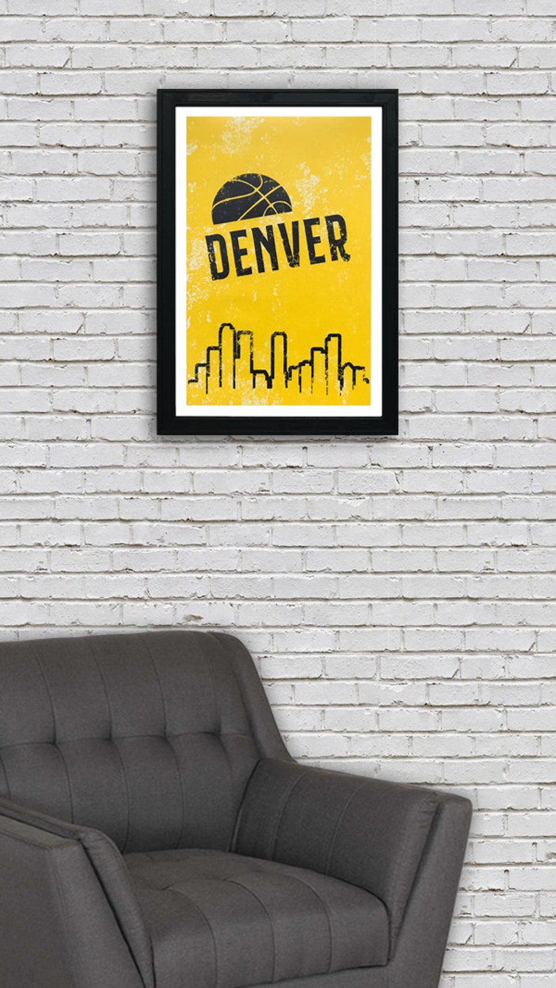 Puede incluir: Un p&oacute;ster enmarcado en negro con fondo amarillo y un gr&aacute;fico de baloncesto negro. El texto "DENVER" est&aacute; escrito en letras negras en el p&oacute;ster. Una silueta negra de un horizonte de ciudad se encuentra en la parte inferior del p&oacute;ster.