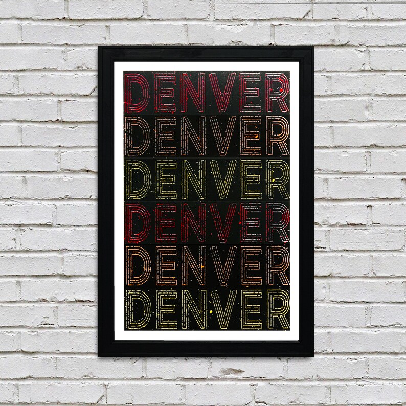 May include: A black framed print with the word "DENVER" repeated six times in a layered, colorful design. The text is in a retro, vintage style with red, yellow, and orange colors on a black background.