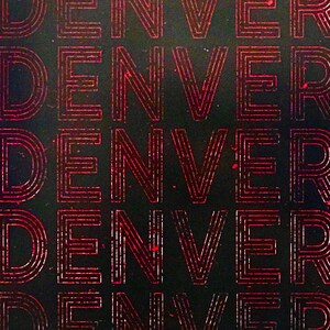 May include: A close-up of a black background with the word "DENVER" repeated multiple times in a red, outlined font.