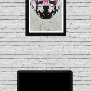 May include: A black and white illustration of a dog wearing pink glasses. The dog is looking directly at the viewer. The illustration is framed in a black frame and hanging on a white brick wall.