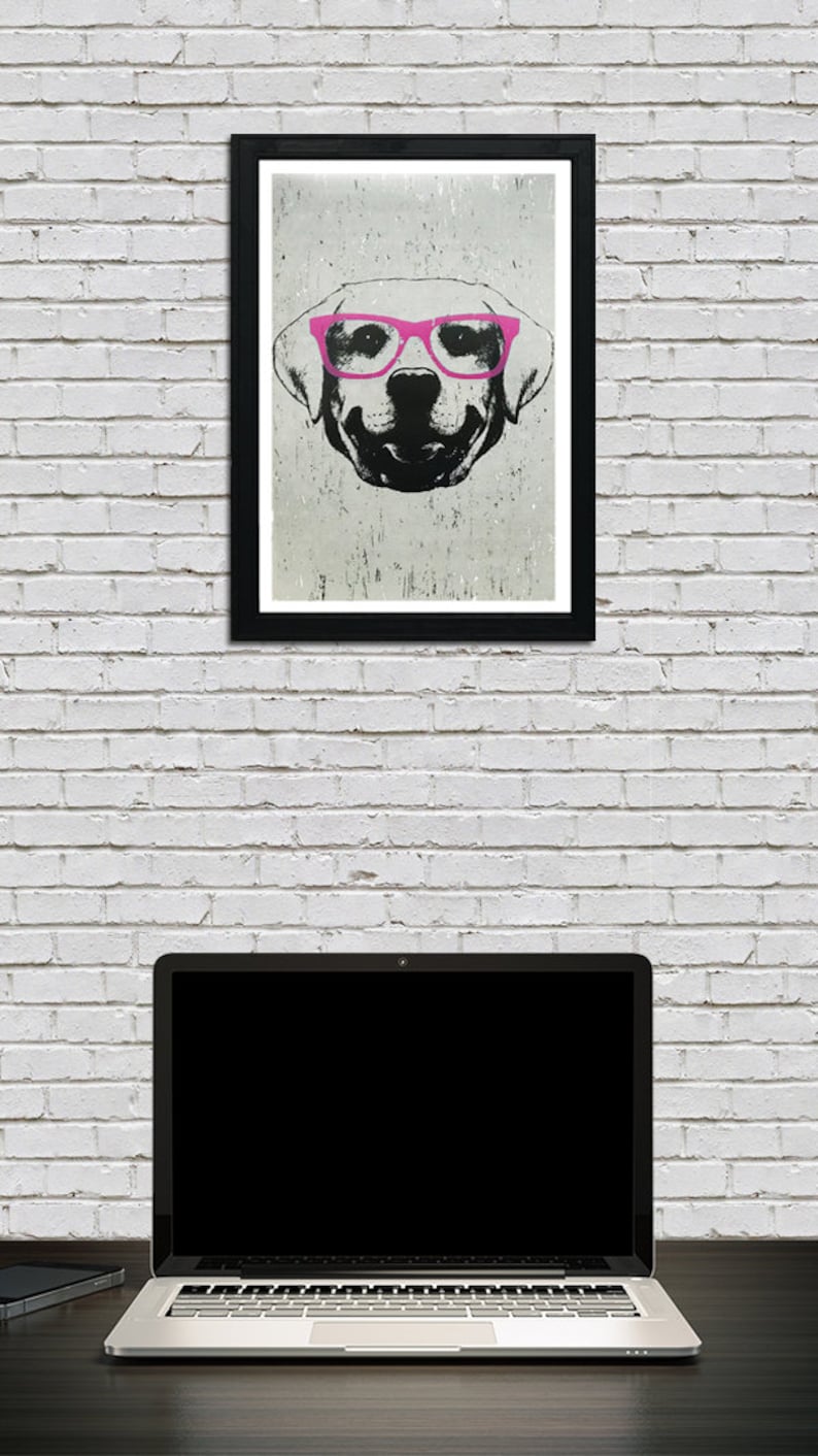 May include: A black and white illustration of a dog wearing pink glasses. The dog is looking directly at the viewer. The illustration is framed in a black frame and hanging on a white brick wall.