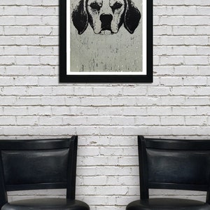 May include: A black and white illustration of a dog's head in a black frame hanging on a white brick wall. Two black bar stools are in front of the wall.