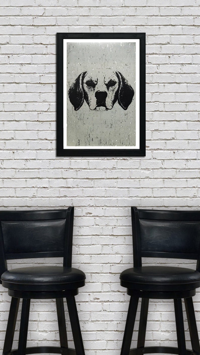 May include: A black and white illustration of a dog's head in a black frame hanging on a white brick wall. Two black bar stools are in front of the wall.